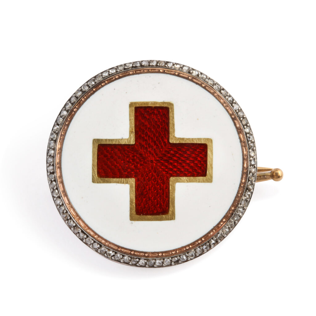 circular brooch with red enamel cross in the center and diamond border