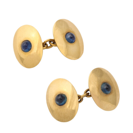 gold oval-shaped double cufflinks, each set with a cabochon sapphire