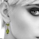 Model wearing peridot and diamond pendant earrings