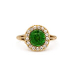 front view of antique gold mounted green garnet ring encircled by diamonds