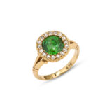 angled view of  antique gold mounted green garnet ring encircled by diamonds