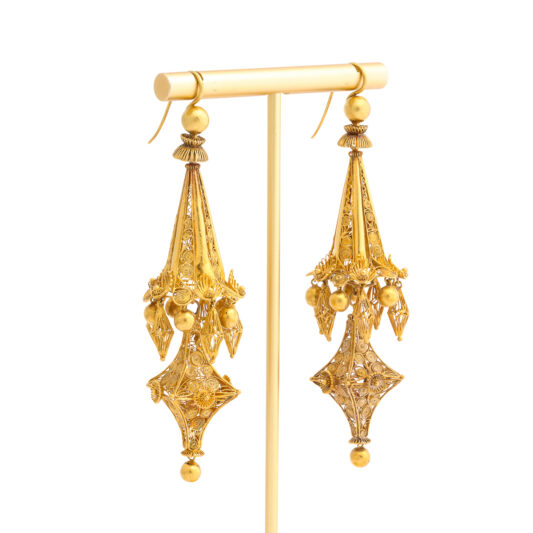Victorian gold filigree pendant earrings photographed on an earring stand