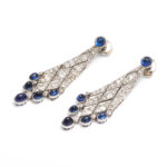 Diamond lozenge shaped pendant earrings set with cabochon sapphires at the top and bottom, top view