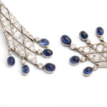 detail view of diamond lozenge shaped pendant earrings set with cabochon sapphires at the top and bottom