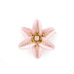 front view of pink enamel flower brooch set with a center diamond and a line of graduated diamonds on each petal