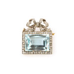 rectangular brooch made with an aquamarine, diamond border, and diamond bow on the top