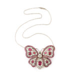 ruby and diamond butterfly brooch pendant shown on a platinum chain