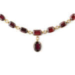 detail view of gold and garnet drop necklace