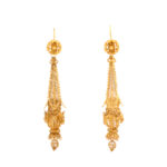 antique gold earrings designed with filigree style wirework, with flower head tops suspending torpedo-shaped pendants
