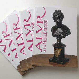 four white catalogs fanned out on a white table, each with "ALVR" text in pink and a picture of a bronze bust