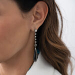 Close up of model wearing onyx and diamond pendant earrings