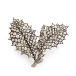 top view of diamond brooch depicting two holly leaves on a twig