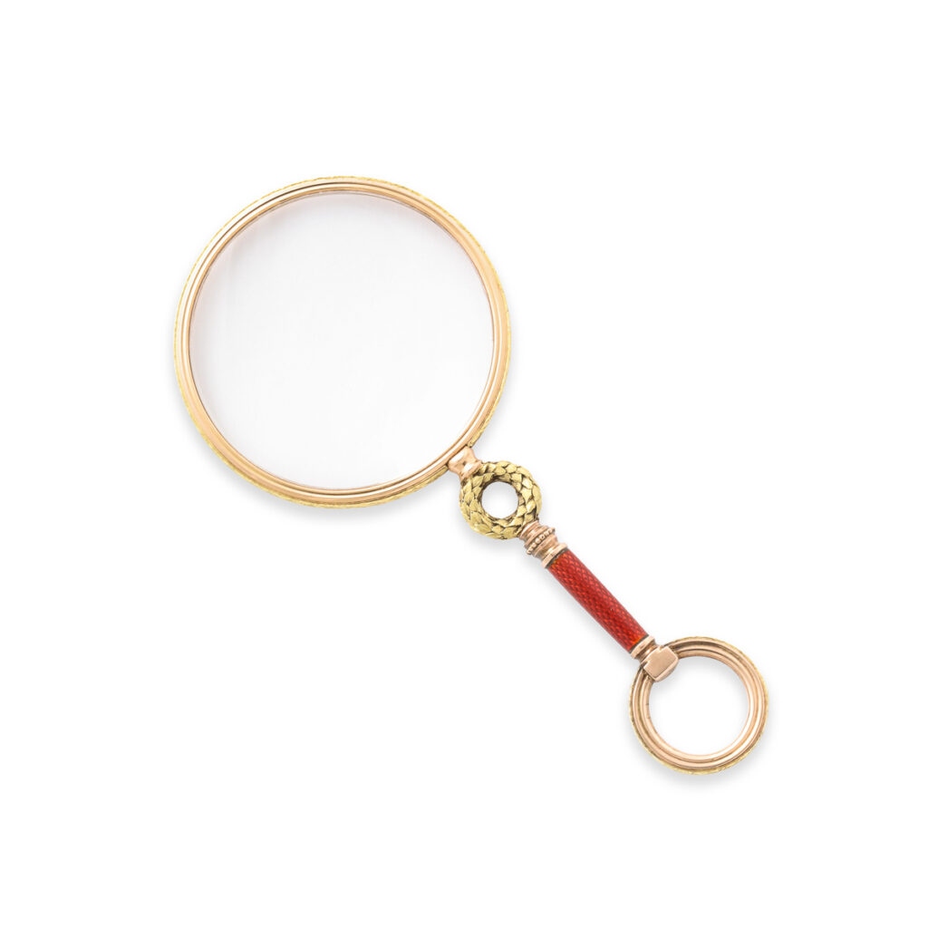 gold magnifying glass with red enamel handle